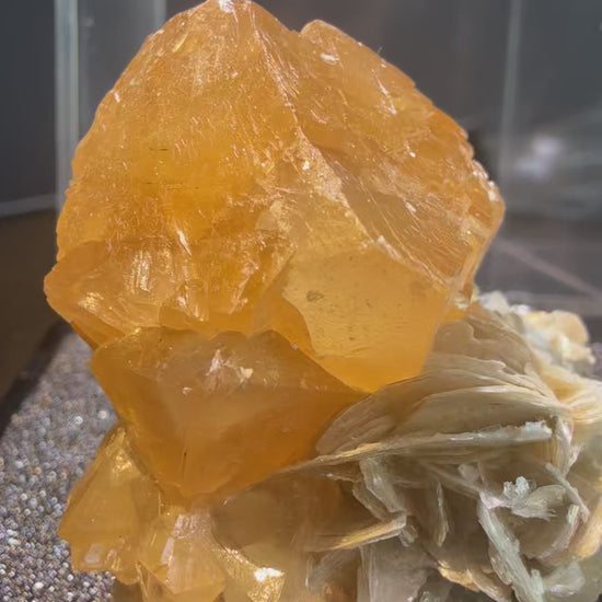Scheelite with Muscovite specimen from Xuebaoding, Sichuan — fiery orange scheelite on silvery muscovite, vitreous to resinous (scheelite), pearly (muscovite) luster, translucent to transparent (scheelite), transparent on edges (muscovite) (4×4×5 cm), 360° rotation video — SCH-0042